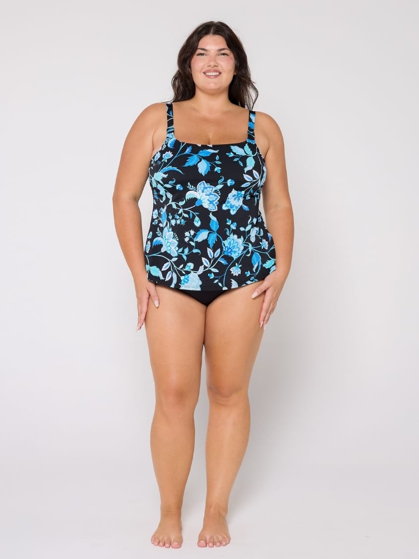 Woman wearing a floral-patterned swimsuit top on a white background