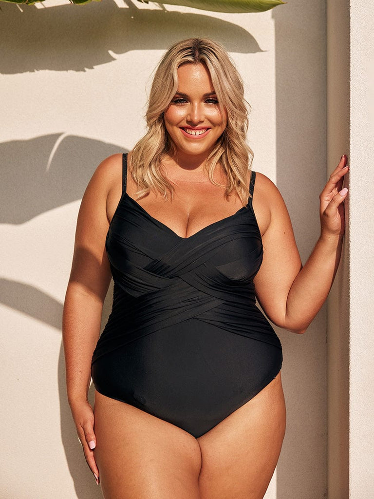 Blonde model wearing black criss cross one piece swimsuit