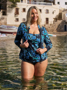 Woman wears zip up long sleeve rashie in blue floral design