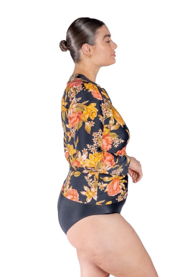 side profile of model in black yellow and coral floral long sleeve rash vest