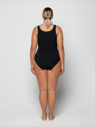 Person wearing a black swimsuit on a white background