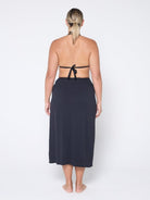 Woman wearing a black halter top and matching skirt on a white background