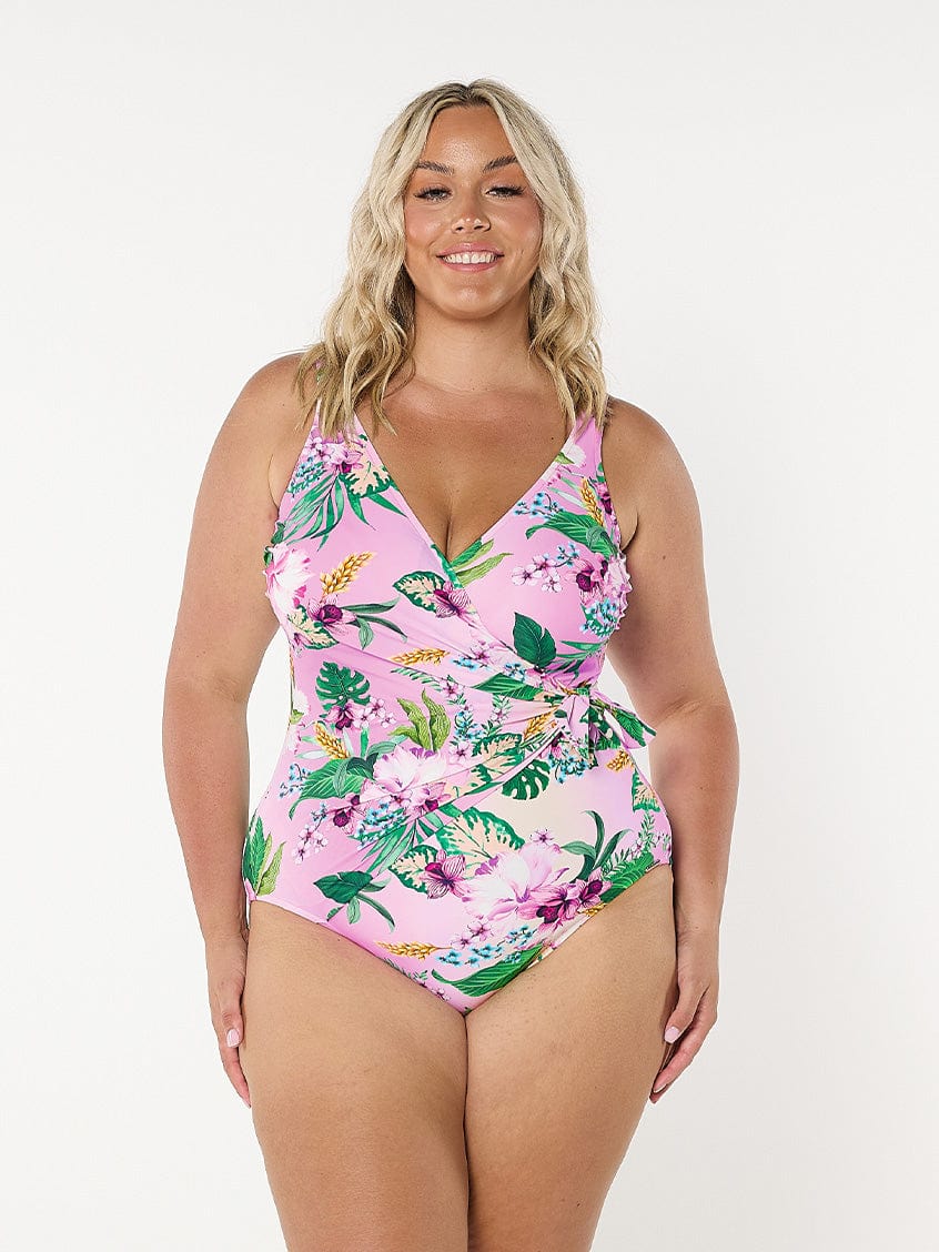 Model in studio wearing waist tie one piece in pink floral print