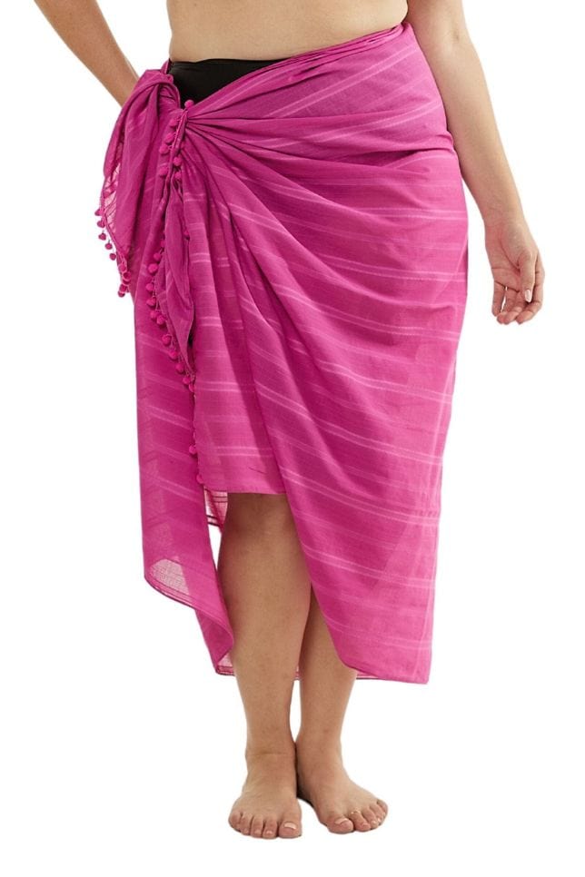 Model wearing hot pink sarong with pom pom details