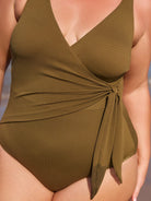 Green swimsuit with a tie detail on a neutral background