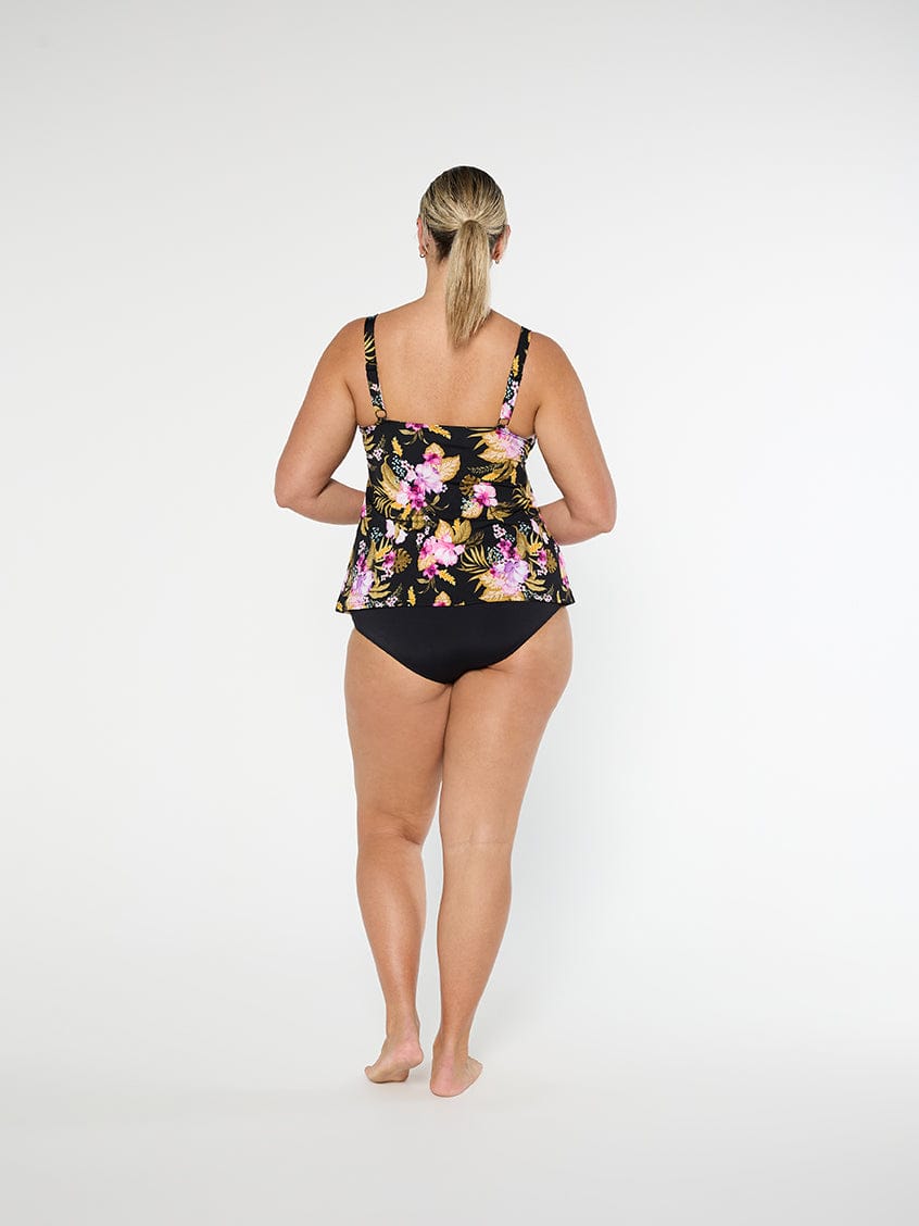 Woman wearing a floral black swimsuit on a white background