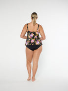 Woman wearing a floral black swimsuit on a white background