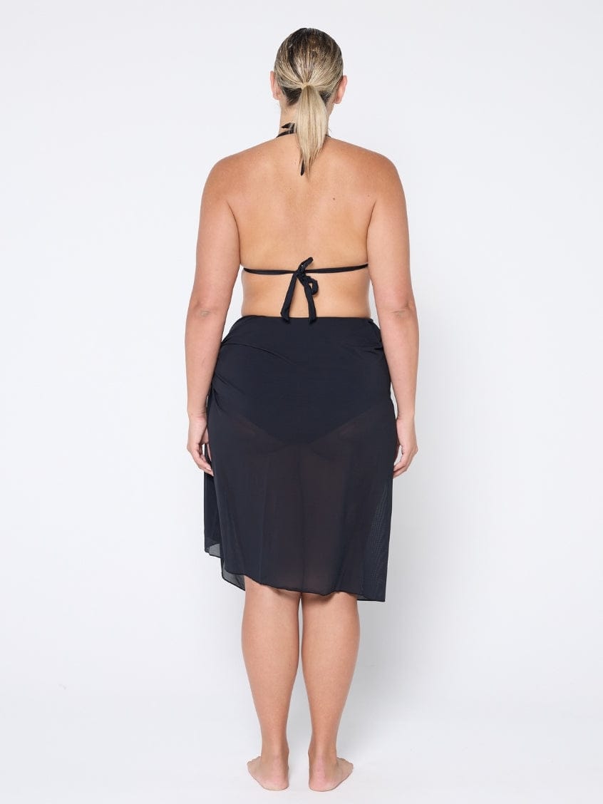Woman wearing a black halter top and skirt on a white background