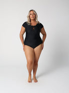 Woman wearing a black swimsuit on a white background