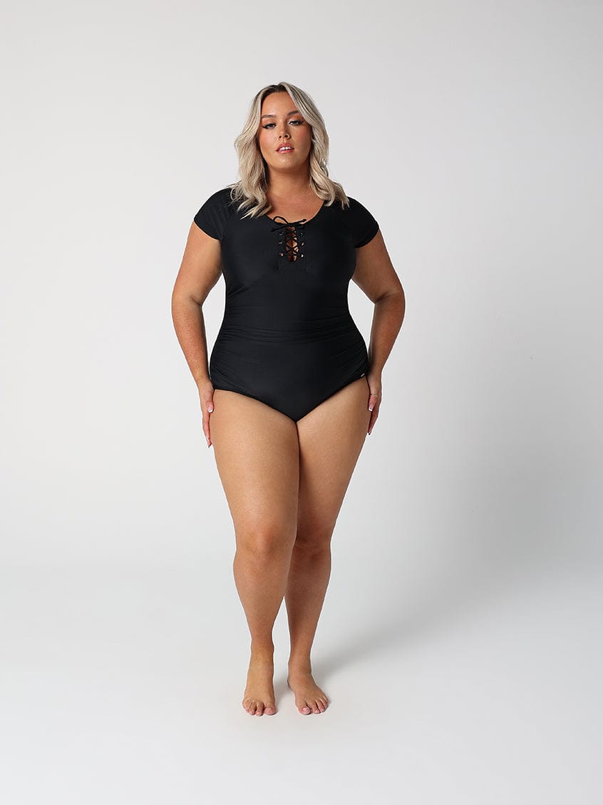 Woman wearing a black swimsuit on a white background