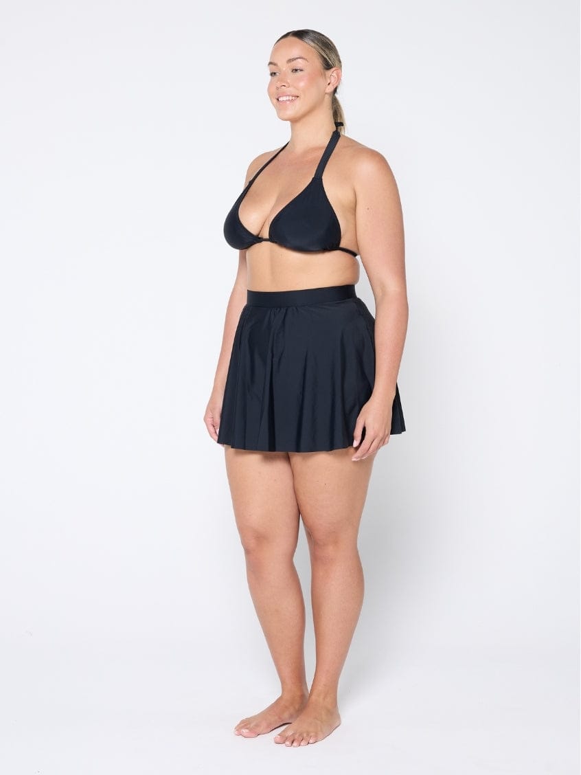 Woman wearing a black two-piece swimsuit on a white background