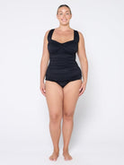 Woman wearing a black swimsuit on a white background