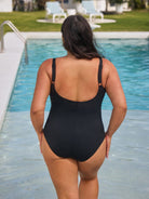 Woman in a black swimsuit standing by a pool