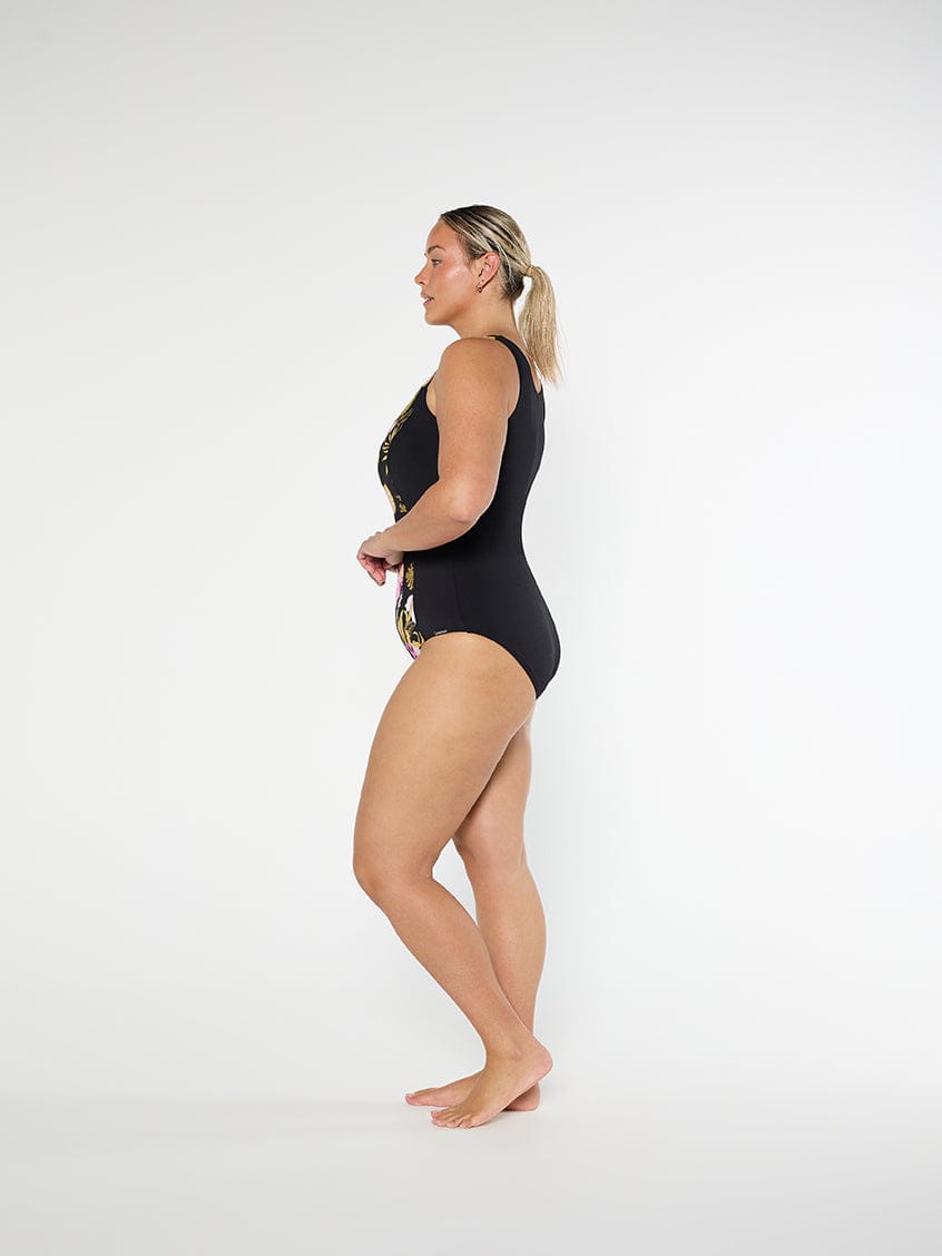 Woman wearing a black swimsuit with lace details on a white background