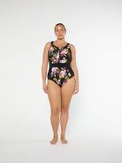 Woman wearing a black floral swimsuit on a white background