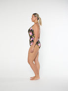 Woman wearing a floral one-piece swimsuit on a white background