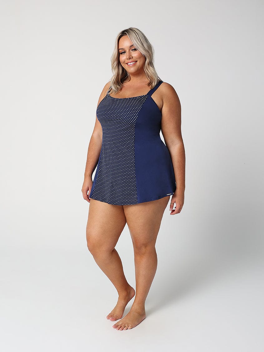 Woman wearing a navy blue patterned swimsuit on a white background