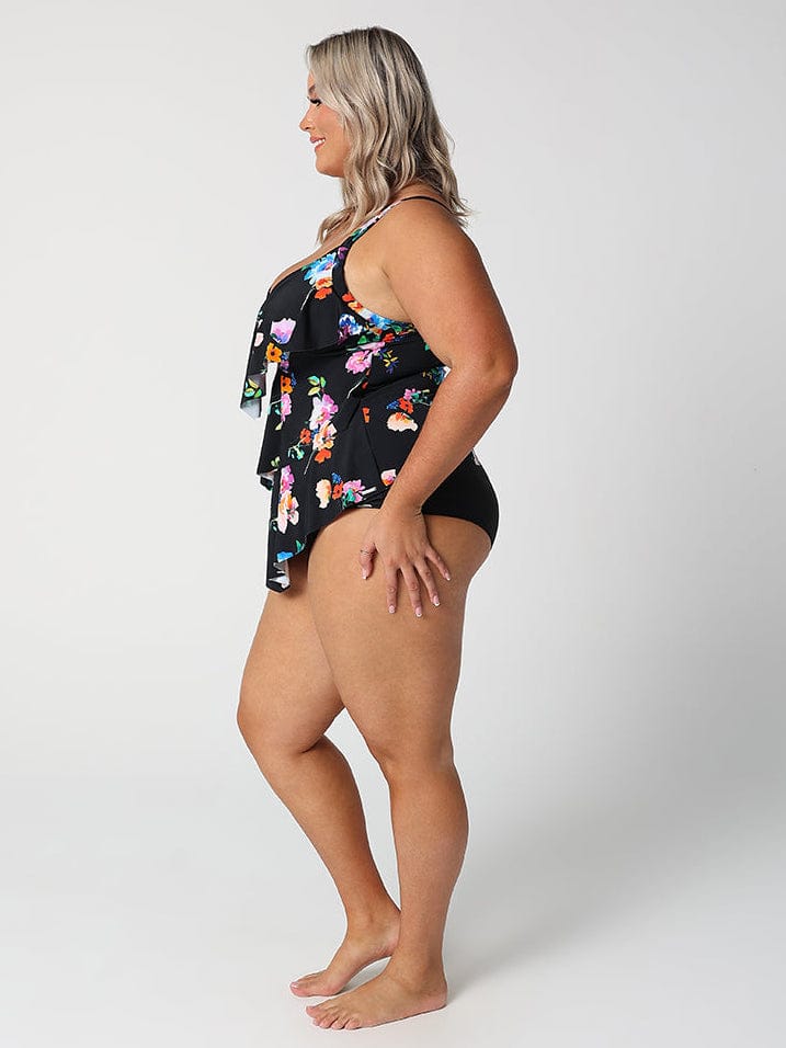 Woman wearing a black floral swimsuit on a white background