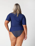 Blonde model showing back of navy short sleeve rash vest