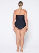 Person wearing a black strapless swimsuit on a white background