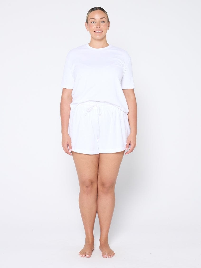 Person wearing a white t-shirt and shorts set on a plain background