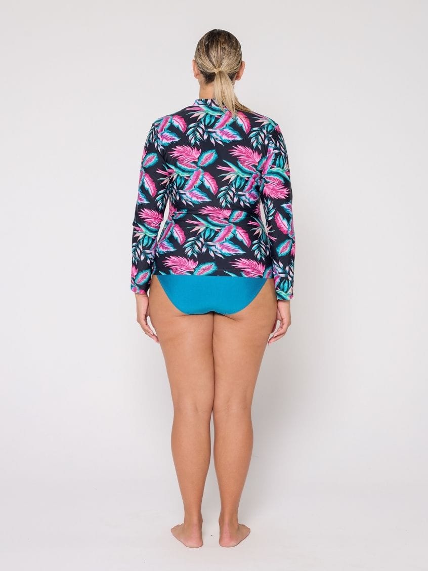 Person wearing a colorful tropical patterned shirt and blue shorts on a white background