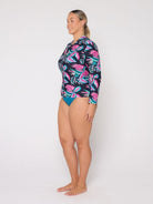 Woman wearing a colorful floral swimsuit on a white background