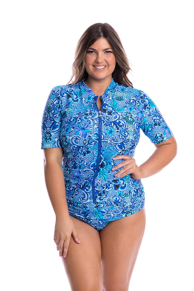 Brunette model wearing blue patterned short sleeve rash vest