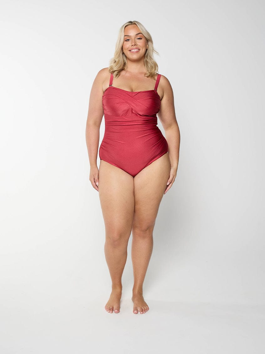 Woman wearing a metallic red swimsuit on a white background