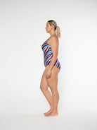 Woman wearing a colorful striped swimsuit on a white background