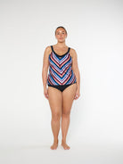 Woman wearing a colorful striped swimsuit on a white background