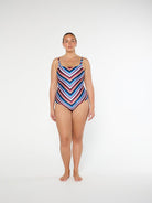 Woman wearing a colorful striped swimsuit on a white background