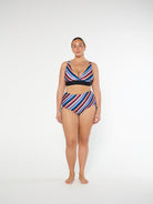 Woman wearing a colorful striped swimsuit on a white background