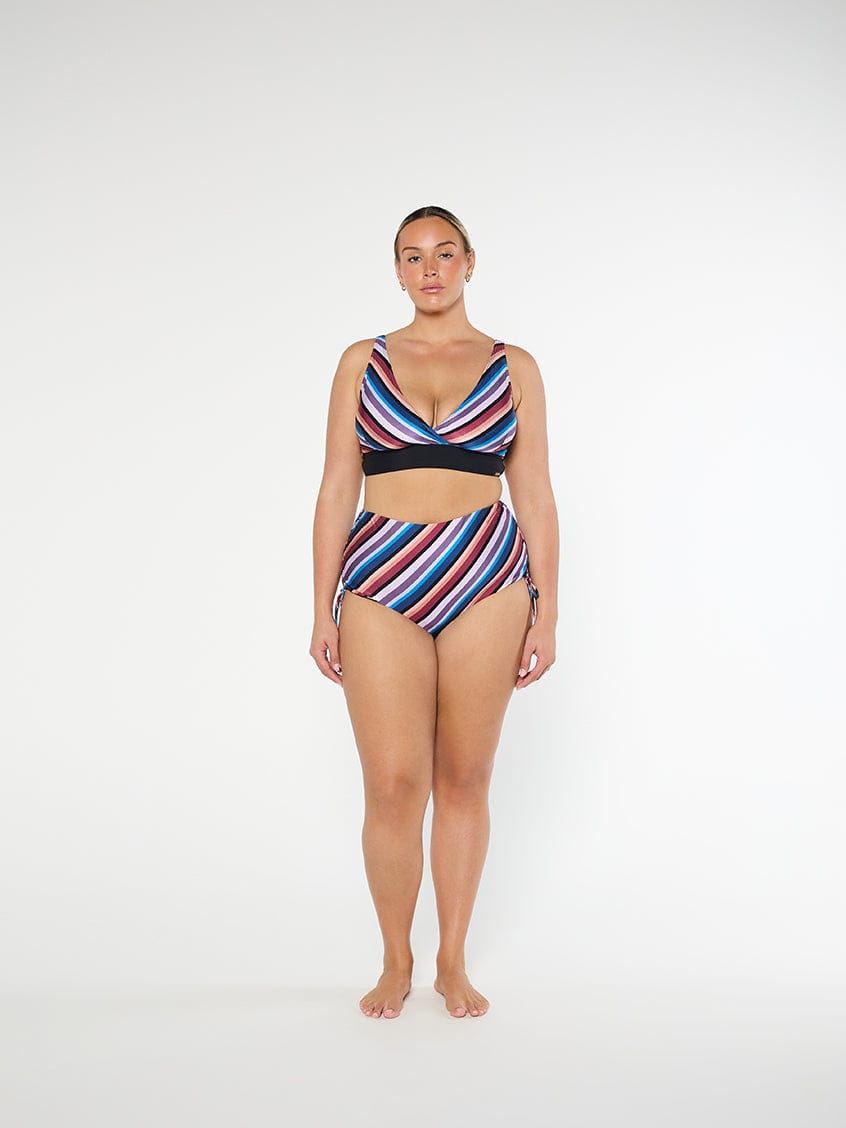 Woman wearing a colorful striped swimsuit on a white background