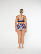 Woman wearing a colorful striped swimsuit on a white background