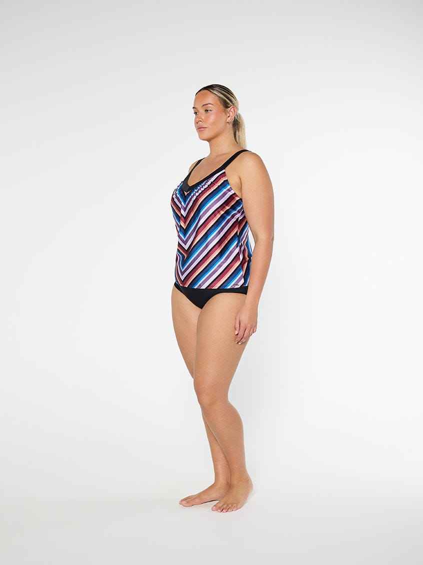 Woman wearing a colorful striped swimsuit on a white background