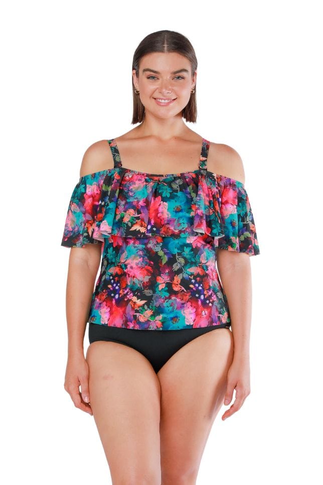 Brunette model wearing multi coloured tankini top with frill detail and removable straps