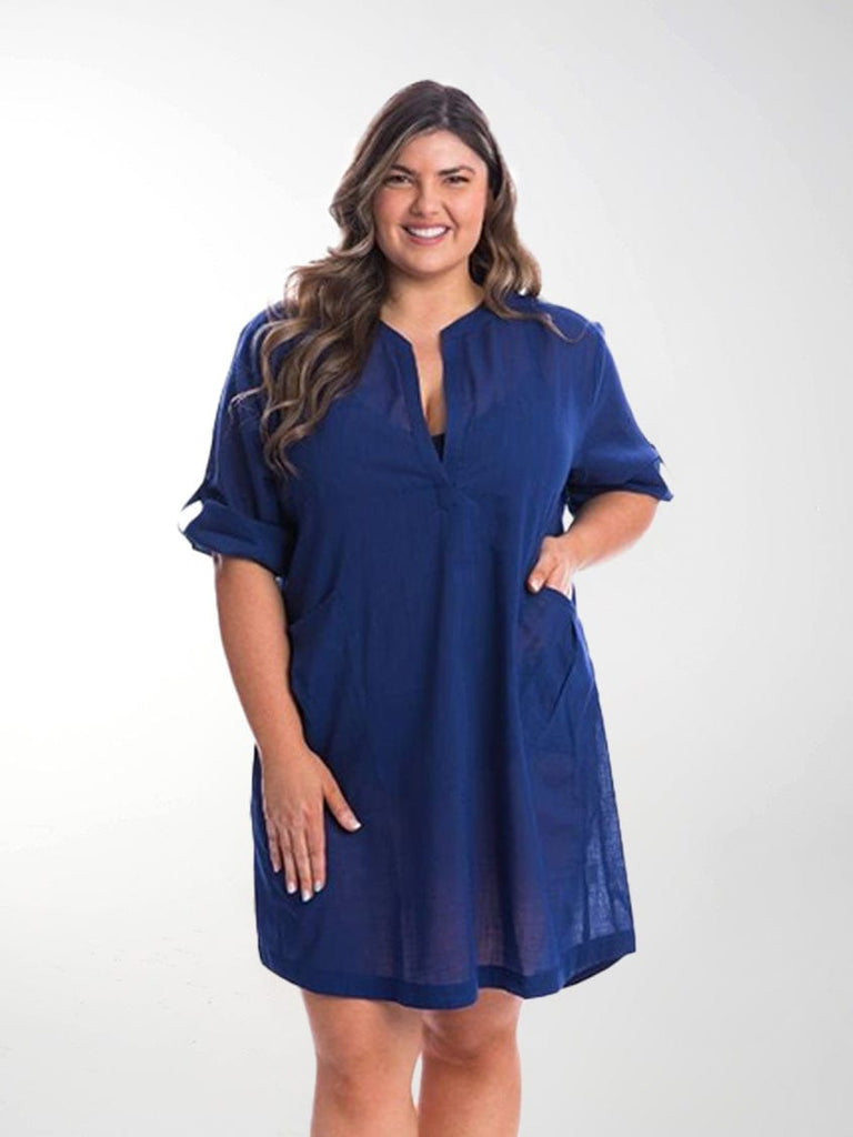 Model in studio wearing oversized shirt dress with rolled up sleeves