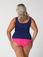 Back of model in studio wearing pink and navy tankini top with full zip in chlorine resistant