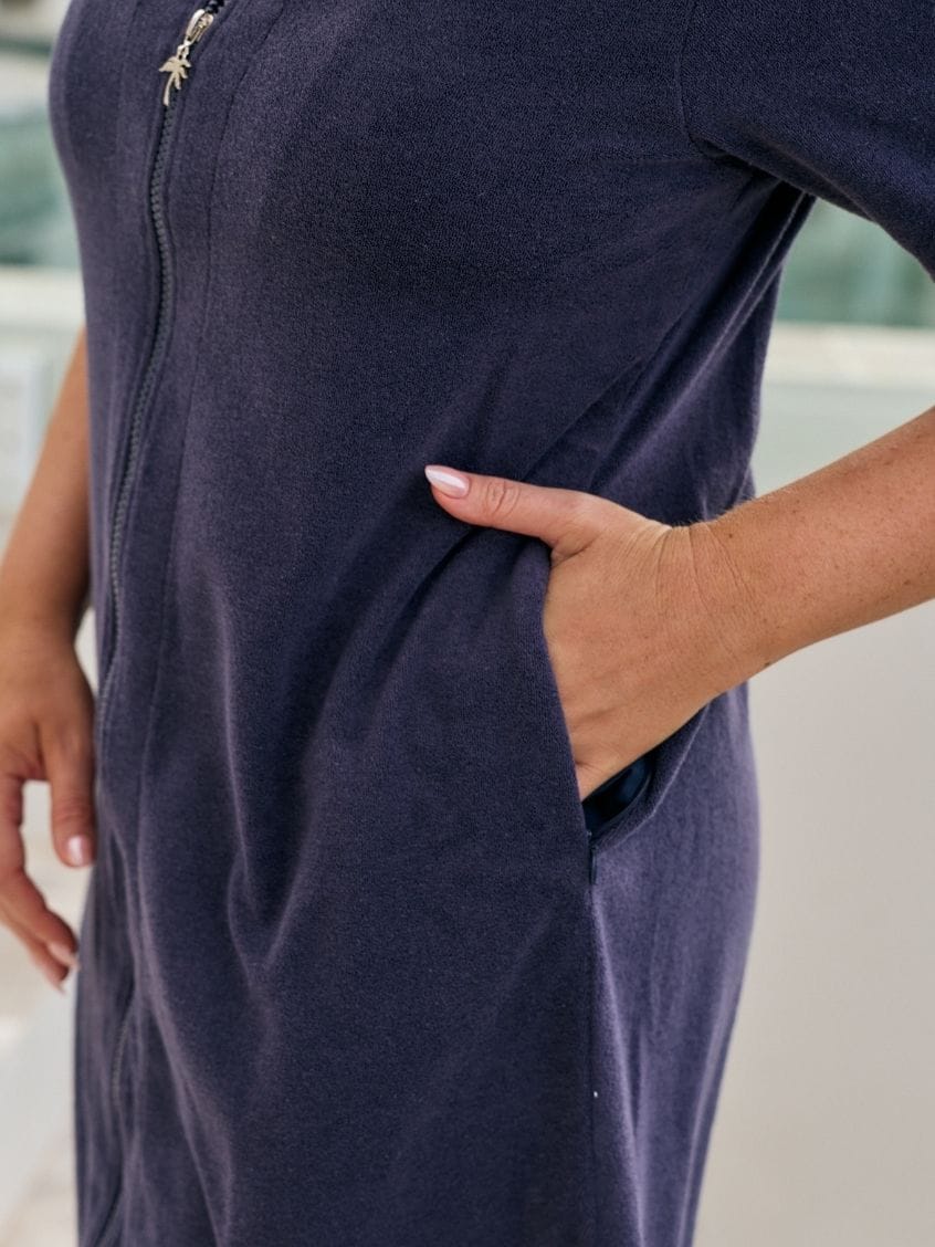 Close up of terry towelling dress in navy with pockets and zip through detail