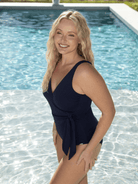 Side profile of blonde model by pool in a honey comb textured fabric one piece with tie detail