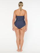 Woman wearing a strapless polka dot swimsuit on a white background