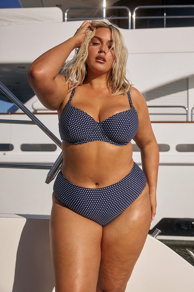 model wearing navy dots bikini set