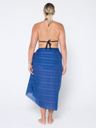 back of model standing in front of a white wall wearing a navy blue sarong