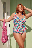 Model holding woven pink tote bag on her arm wearing swimwear