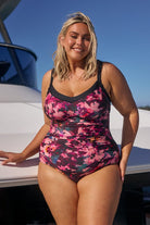 Model wearing pink and plum underwire one piece swimsuit