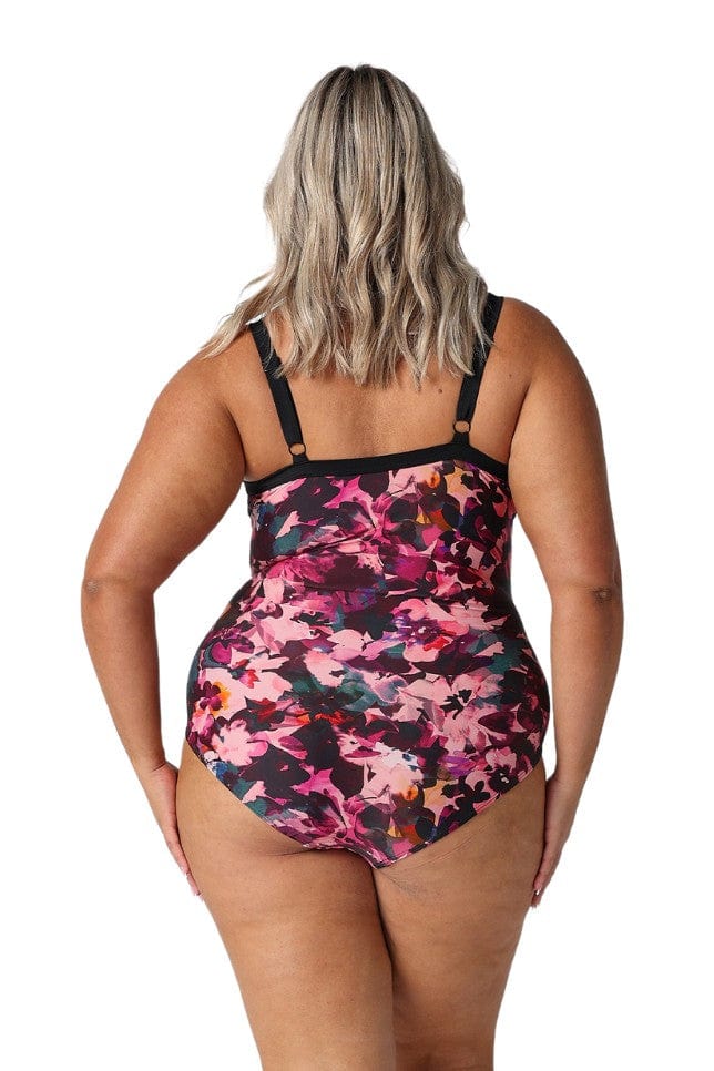 Model showing back of pink and plum one piece swimsuit