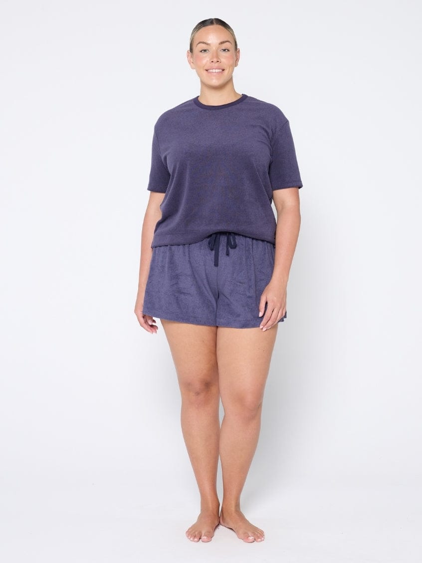 Woman wearing a navy terry towelling
 set on a white background