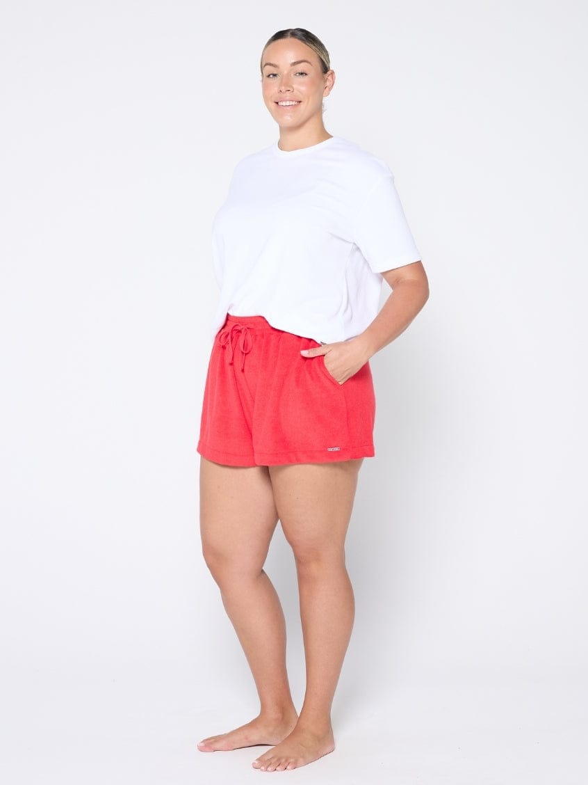 Person wearing red shorts and a white shirt on a white background