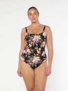 Blonde model wears flattering chlorine resistant one piece swimsuit in gold and pink florals